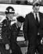 February 21, 1970: Escorted by an MP and CID Special Agent Jim Reeves, Jeffrey MacDonald attends funeral services for Colette, Kimberley and Kristen MacDonald