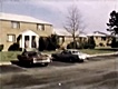 Feb. 17, 1970: Front of 544 Castle Drive. The two front doors under the white-peaked overhang belonged to the Kalin family (left) and the family of Jeffrey MacDonald (right). The residence of Janice and Charles Pendlyshok can be seen on the far right.<br><br>The MacDonalds occupied a single floor.  The window of Kimberley MacDonald's bedroom, where he body was found, is visible to the right of the large shrub in center, and a window of the east bedroom where the body of Colette MacDonald was found appears to the right of Kimberley's window.