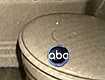 Cloth toilet seat cover bearing red-brown stain from hall bathroom (circled area of Exhibit D55 on toilet seat cover is visible above ABC logo)
